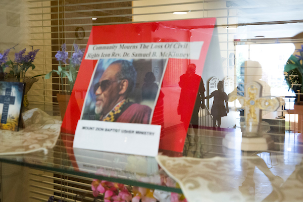 A newspaper clipping of the late Rev. Samuel B. McKinney is pictured in a display case as church members are reflected in the glass following service at Mount Zion Baptist Church in Seattle on Sunday, May 27, 2018.