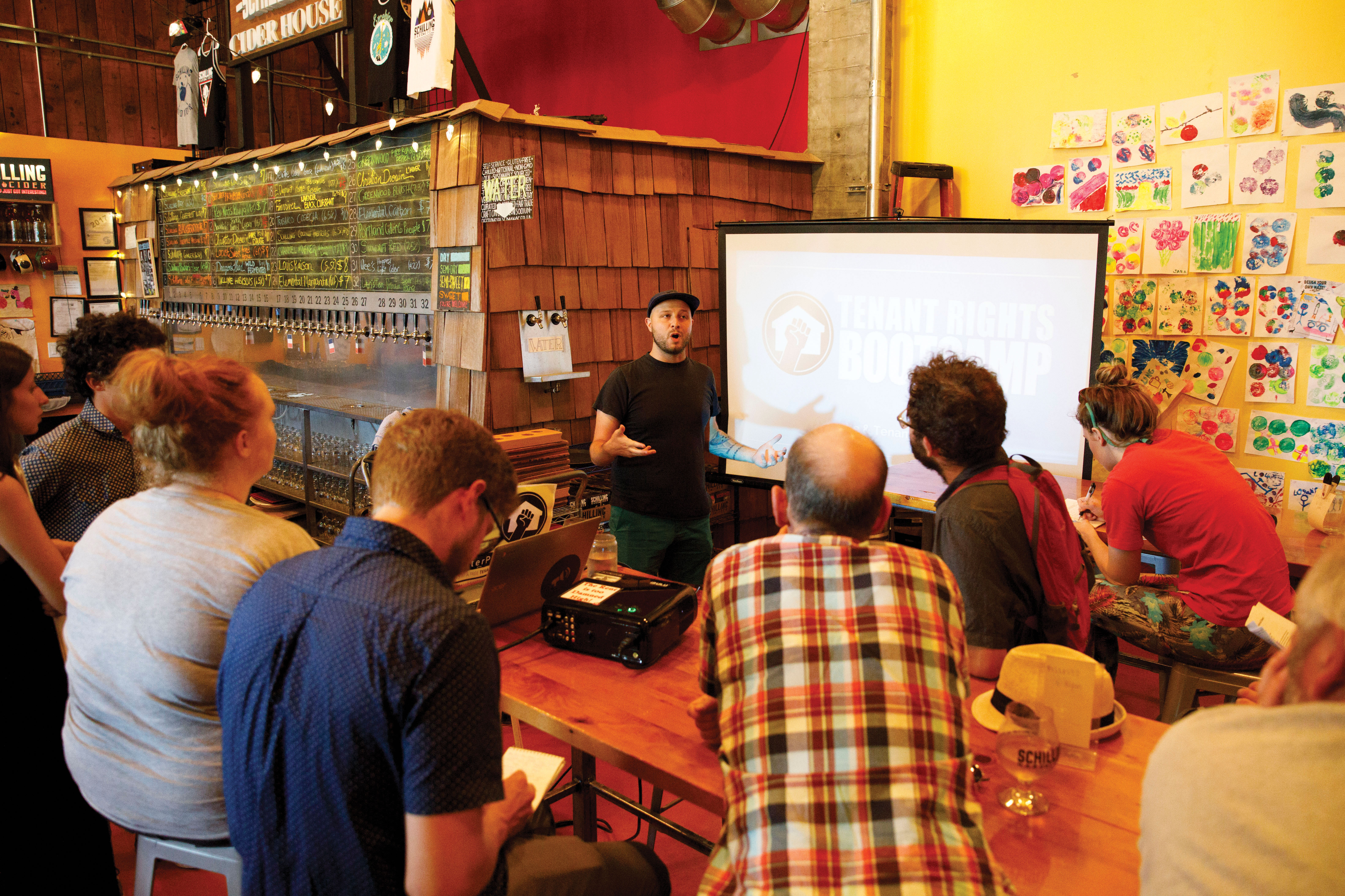 Devin Silvernail, center, leads a Tenant Rights Bootcamp on Wednesday, July 25, 2018 at Schilling Cider House in Fremont, Seattle, WA. The event was hosted by Be:Seattle and provided information on Seattle tenants rights. (Sarah Hoffman/Crosscut)