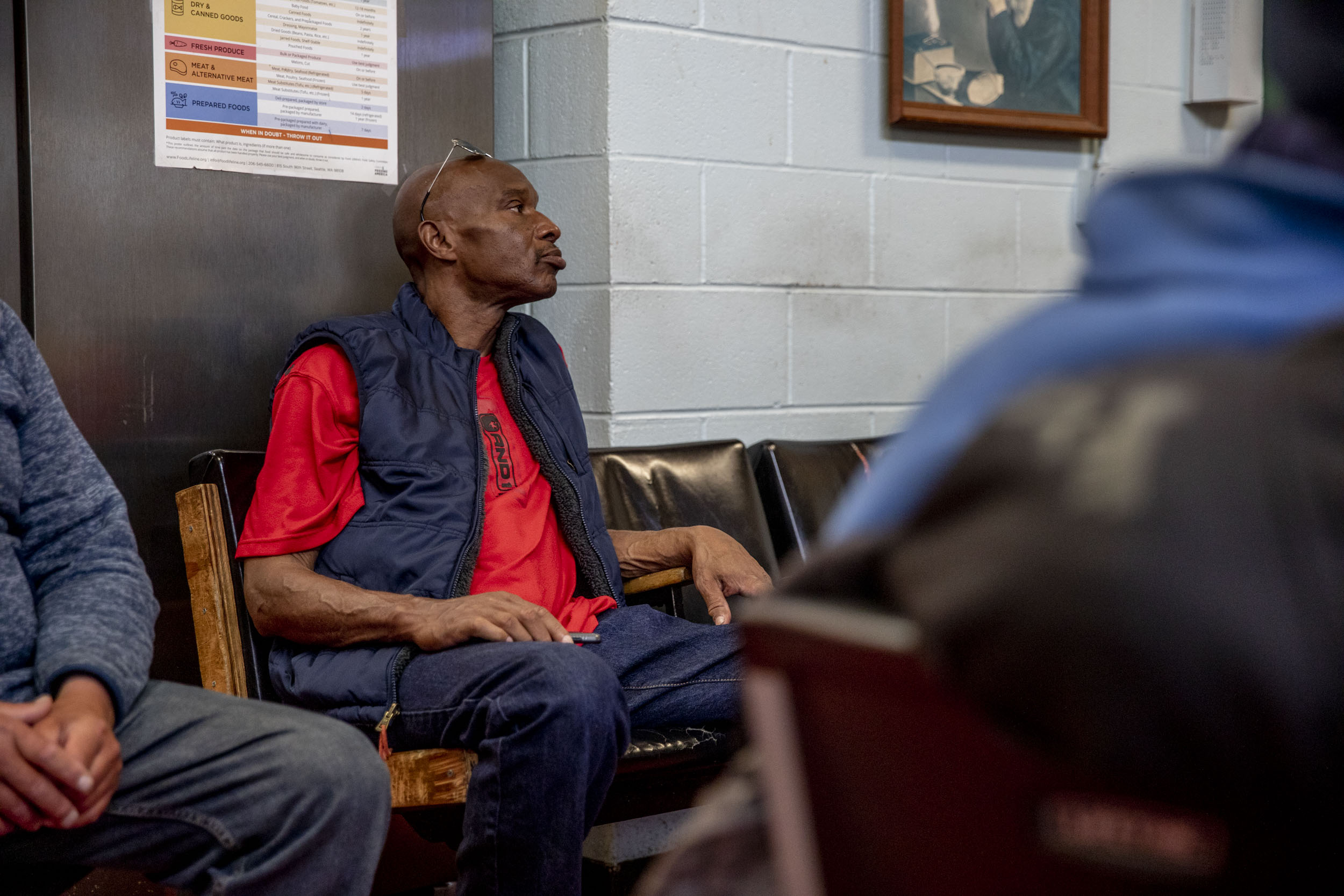man sitting in a common area of homeless shelter
