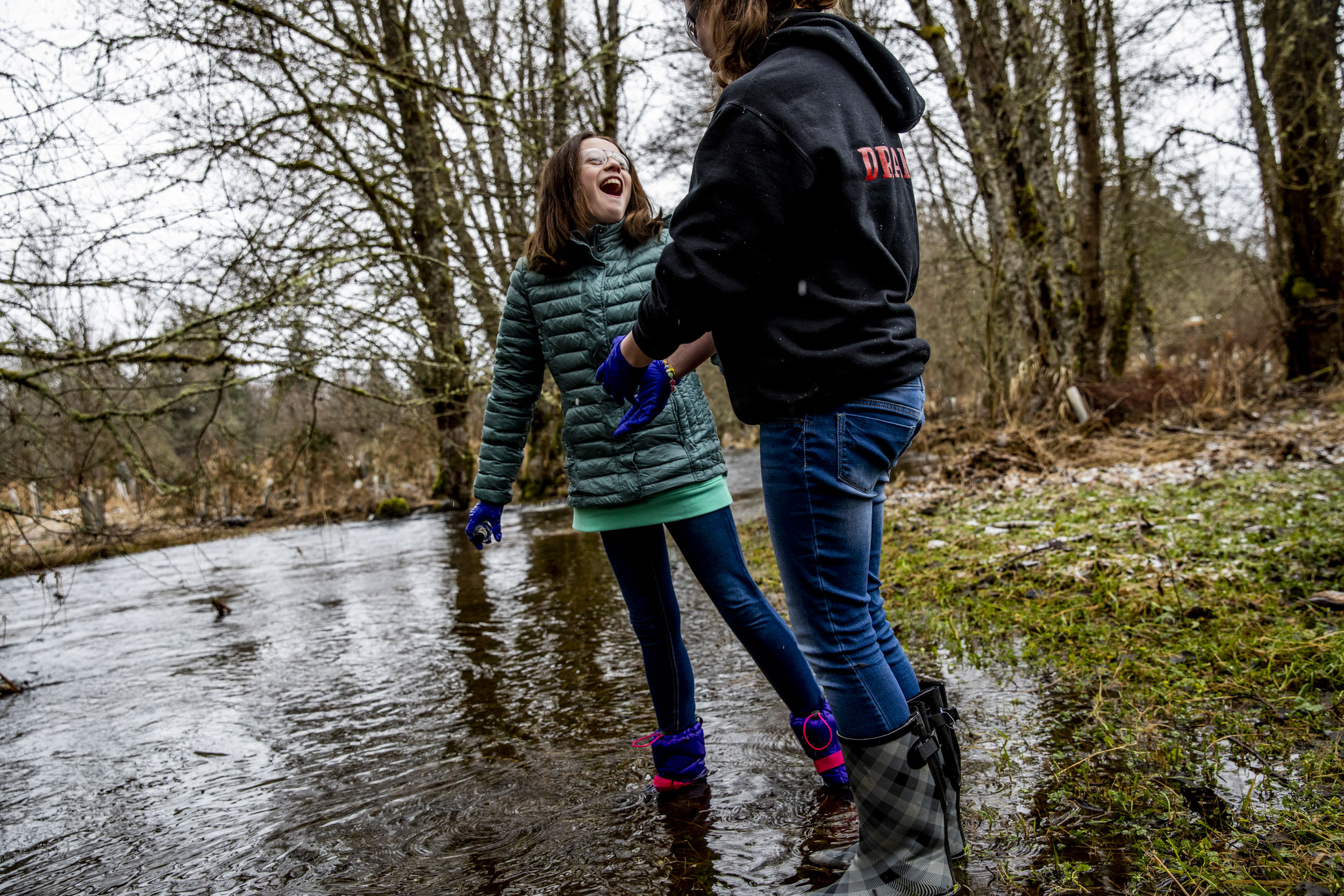 Sixth graders Taylor Drake, right, and Lexi Thompson collect water samples from Muck Creek.