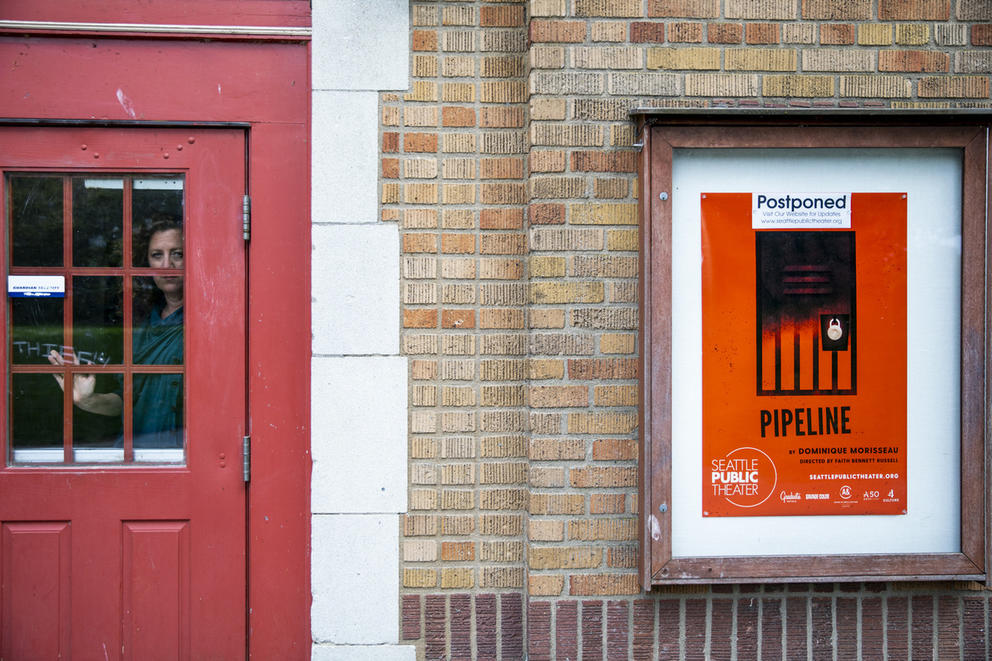 Person behind door and poster of postponed theater show