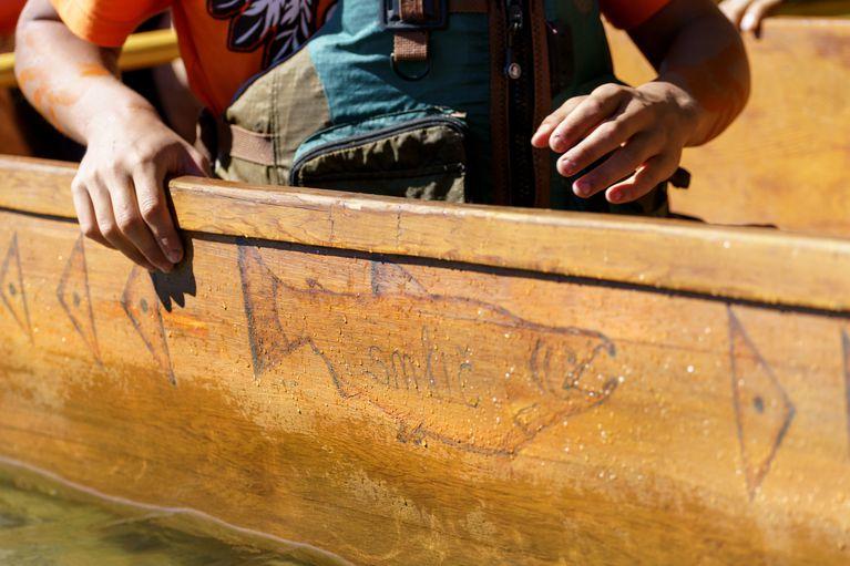 Carving of a salmon on the side of a canoe