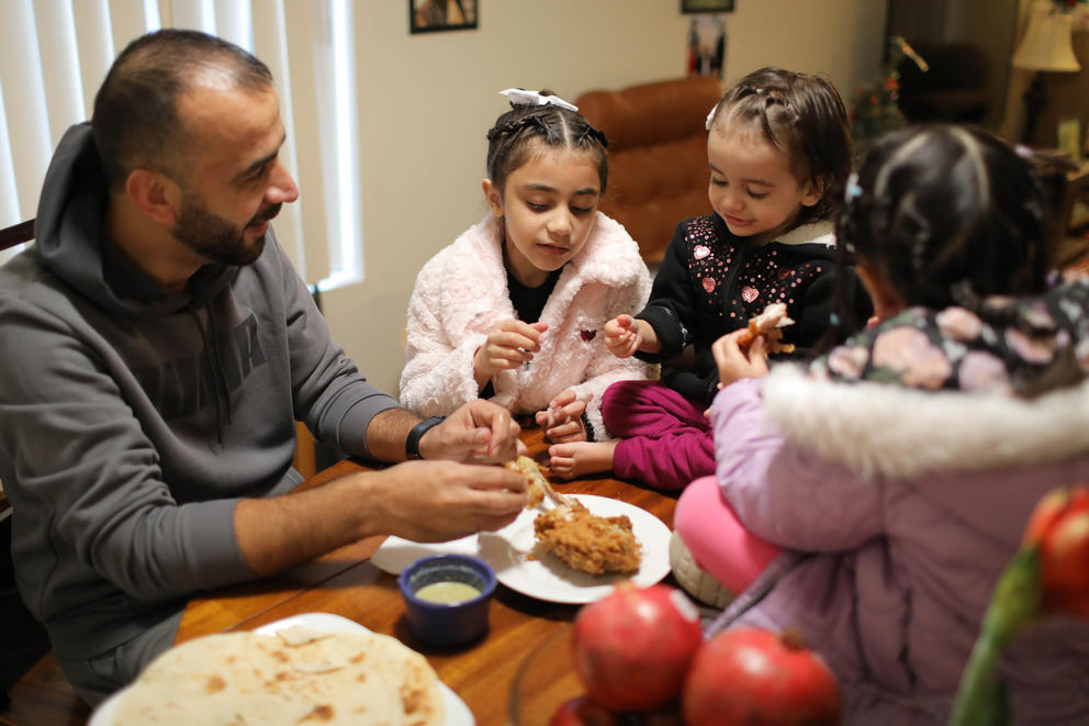 Reshad Al Noori eats fried chicken with his daughters, Mehrin, 6, Behtrin, 2, and Maryan, 4