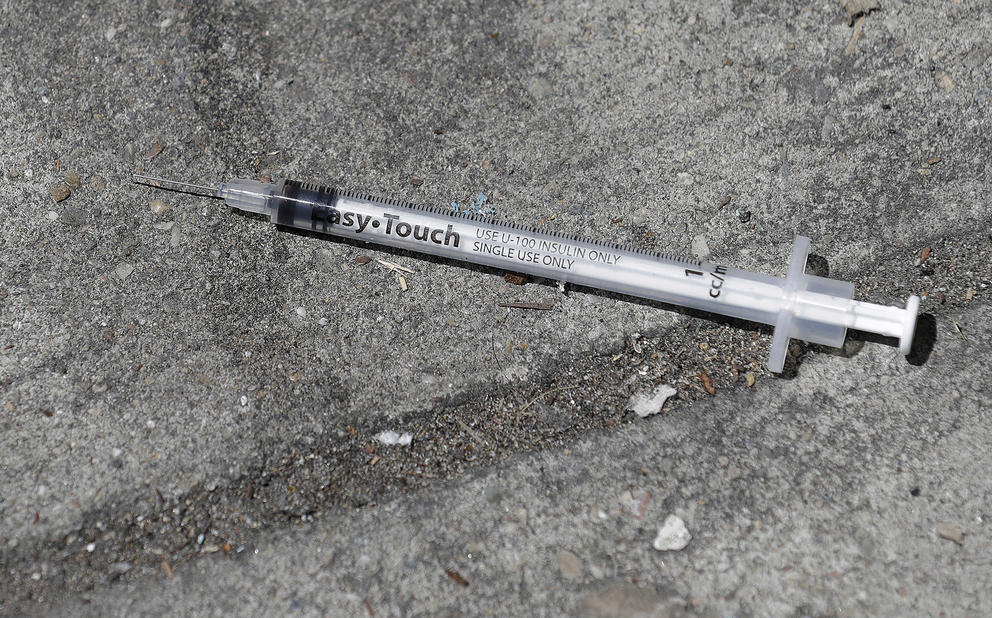 syringe on a sidewalk