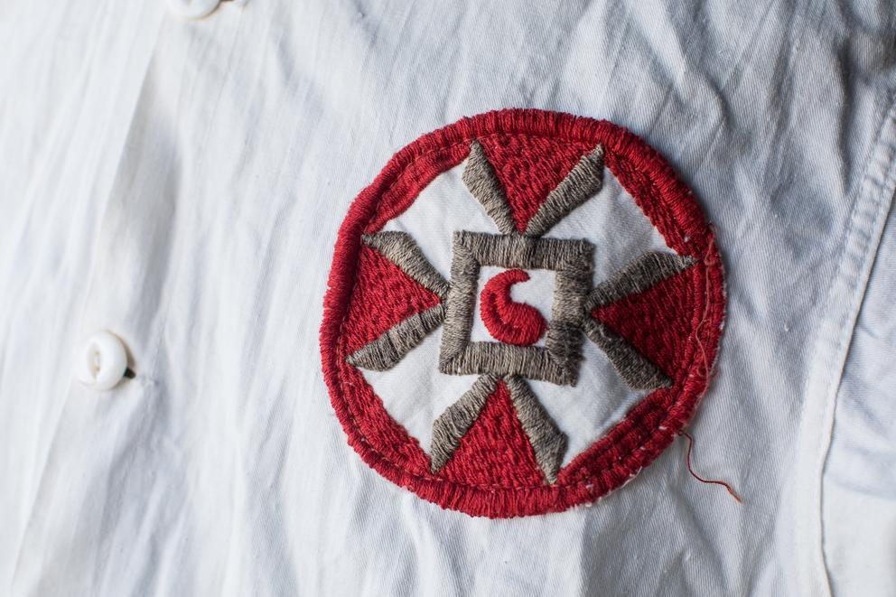 Close-up of a badge sewn into an old Ku Klux Klan robe