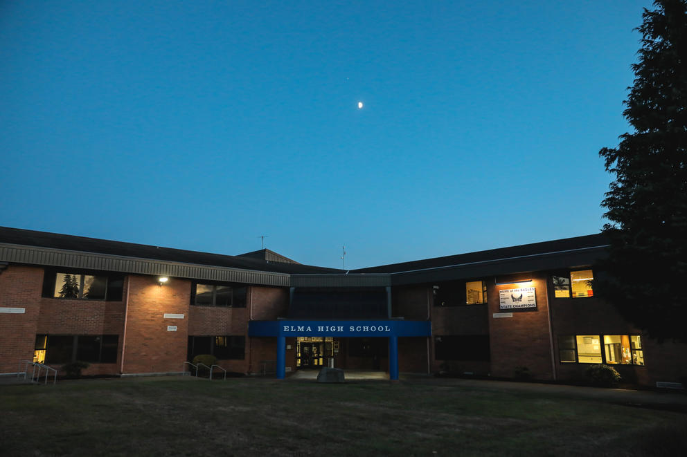 The moon hangs over Elma High School at dusk