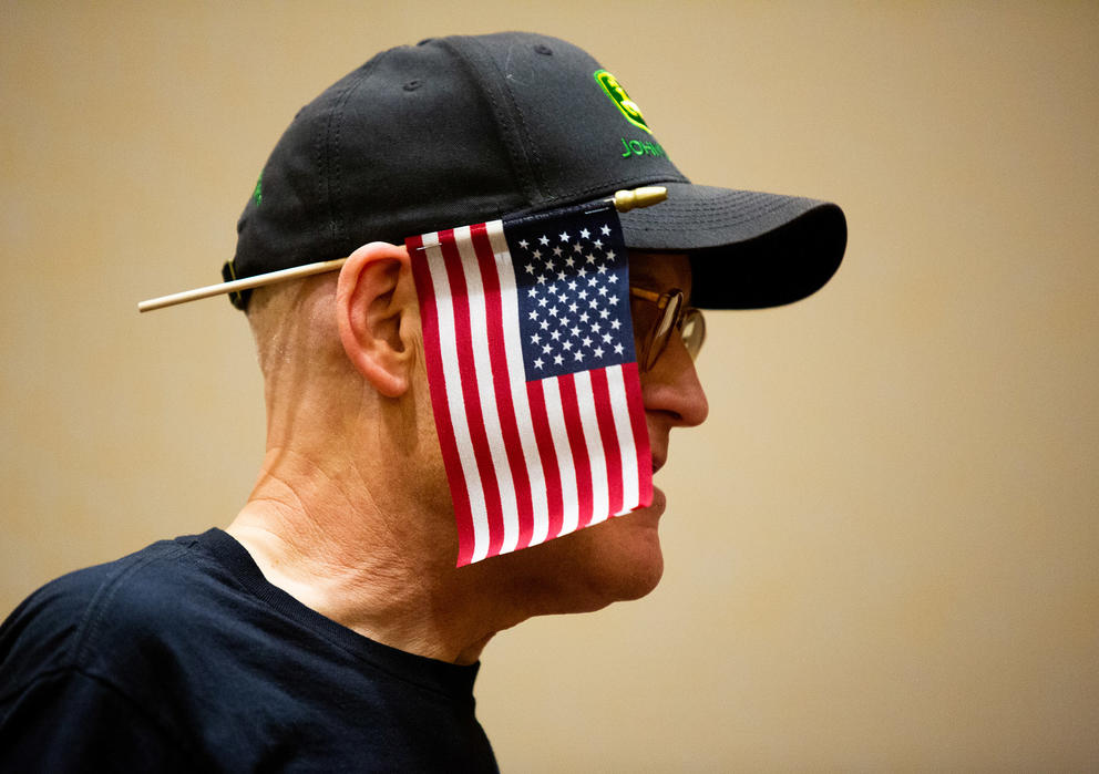 A man has a small american flag hanging in front of his face
