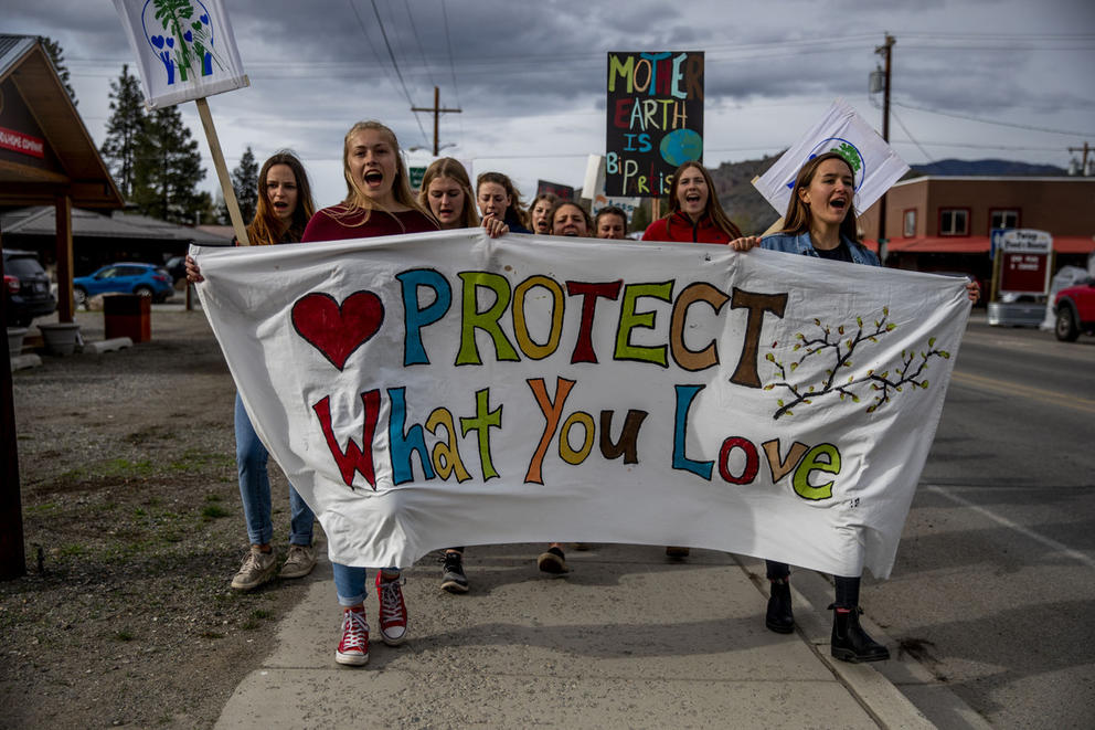 Students holding a banner that reads "Protect what you love"