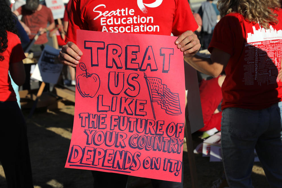 man holds a sign during Seattle teacher contract negotiations