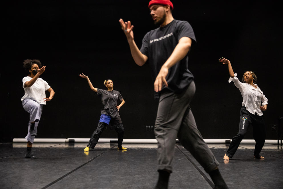 a group of dancers in rehearsal in a black-box theater