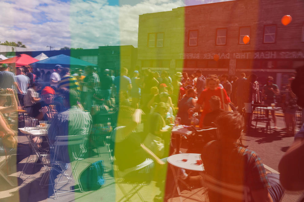 a festival seen thru a pride rainbow flag