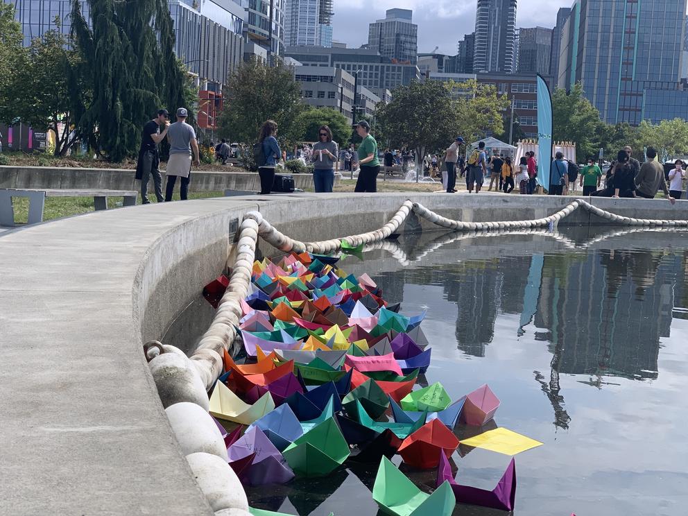 photo of colorful paper boats in a pond