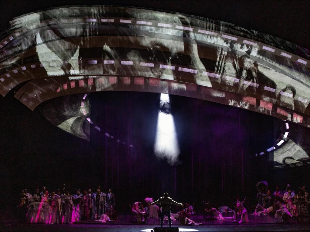 photo of a stage performance with a large gray spaceship appearing to "beam up" a man below