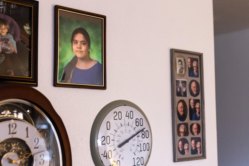 A wall with family photos and a clock.