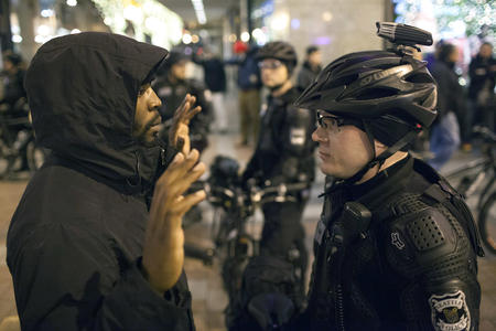 A black man face to face with a white male police officer