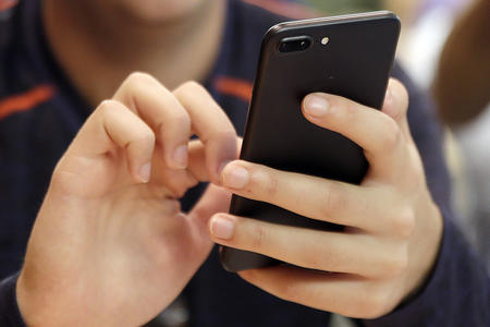 a pair of hands holds a smartphone 