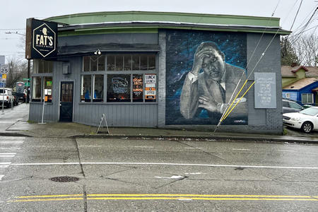 a photo of a building on a Seattle street, left side is Fat's restaurant, right side is a mural of Martin Luther King