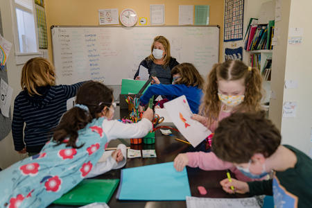 A photo of a teacher and students in a classroom.