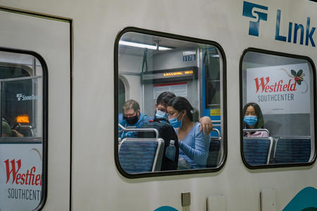 People in masks on light rail