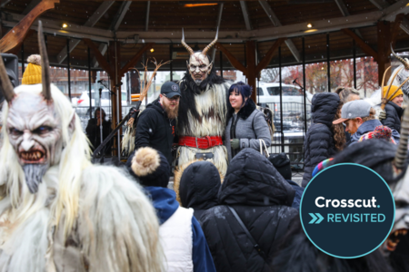 People dressed up as Krampus, a white-furred, horned Christmas demon who scares misbehaving children, pose for photos with people in downtown Leavenworth.