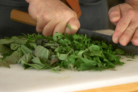 Tad Mitsui chops herbs on a cutting board