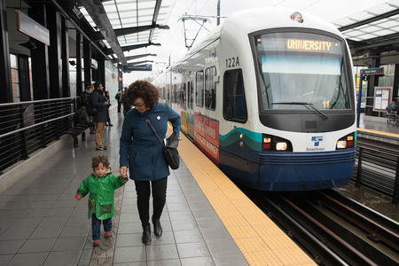 woman walking toward a train with her son