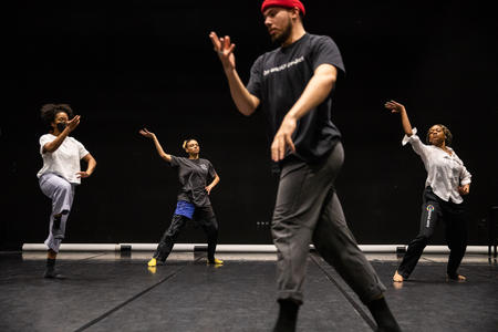 a group of dancers in rehearsal in a black-box theater