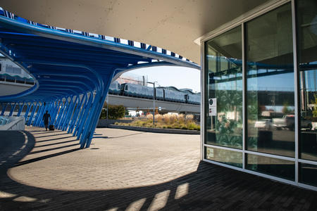 On the right, windows to a building; on the left, blue boomerang artworks over a parking garage