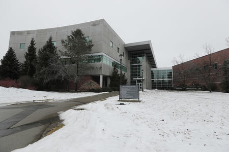 A modern university building on a snowy day.
