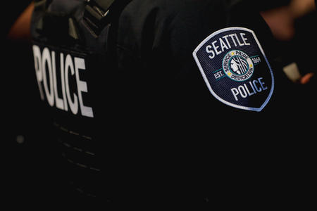 A police officer wears the Seattle police insignia on the right shoulder of a shirt.