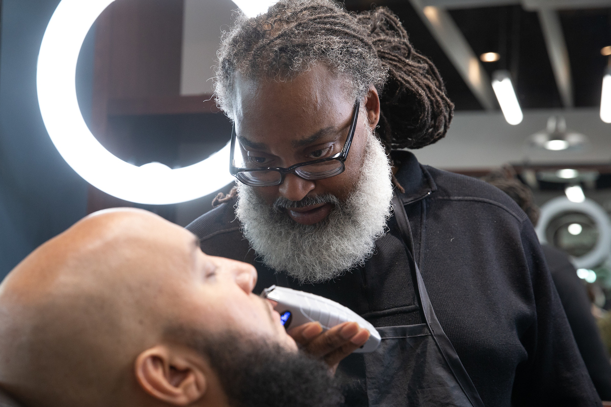 Barber trims client's beard