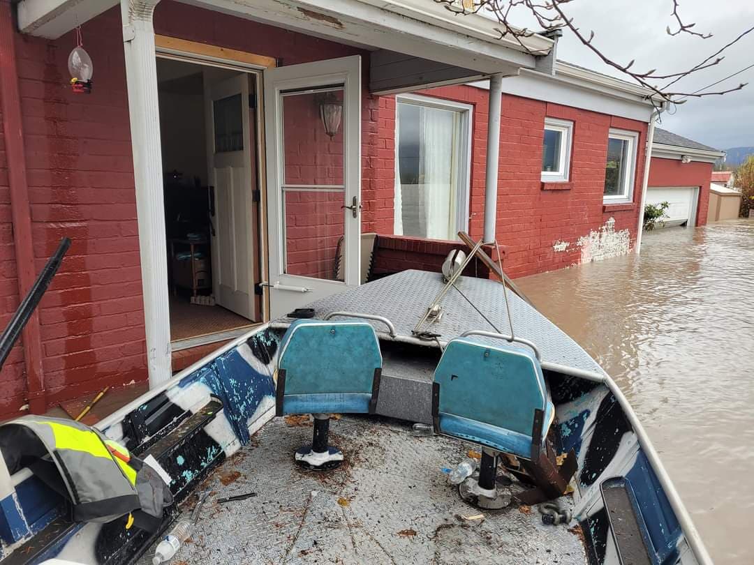 Boat on the water outside of a flooded home