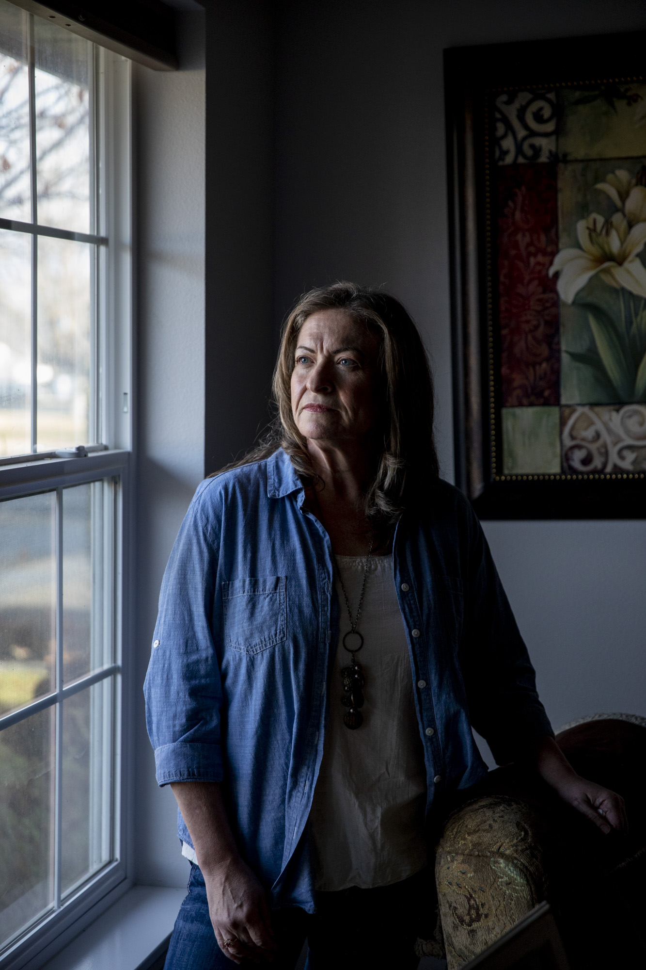 Penny Quist stands by a window inside her home