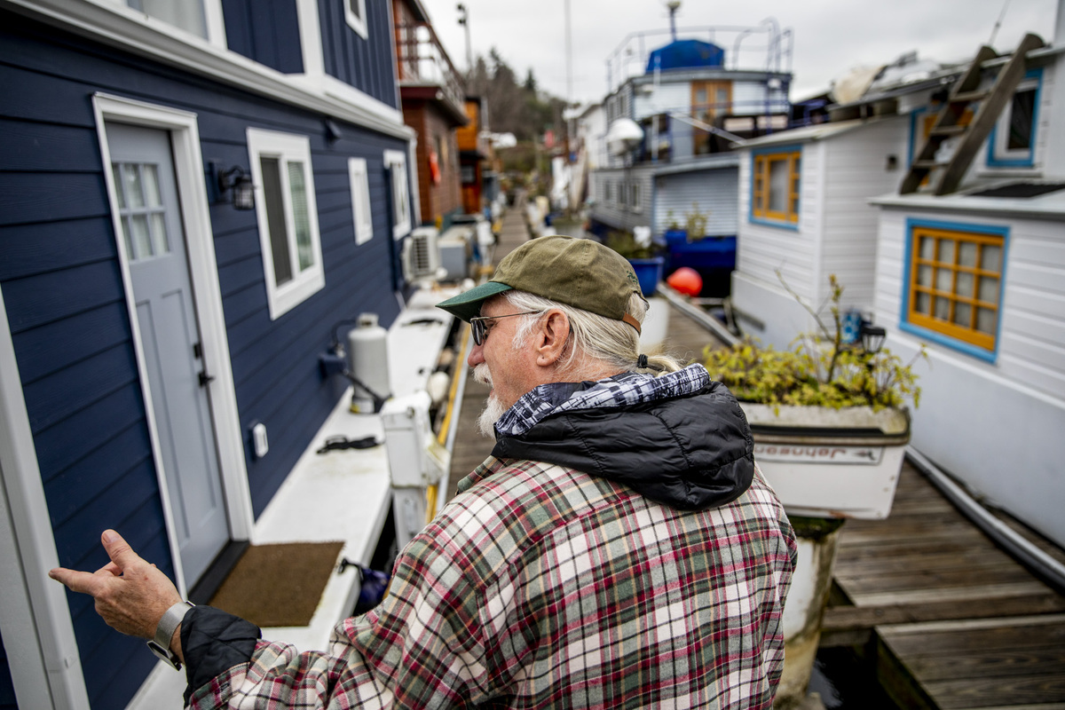 John Chaney walks among house boats on Seattle's Nickerson Marina