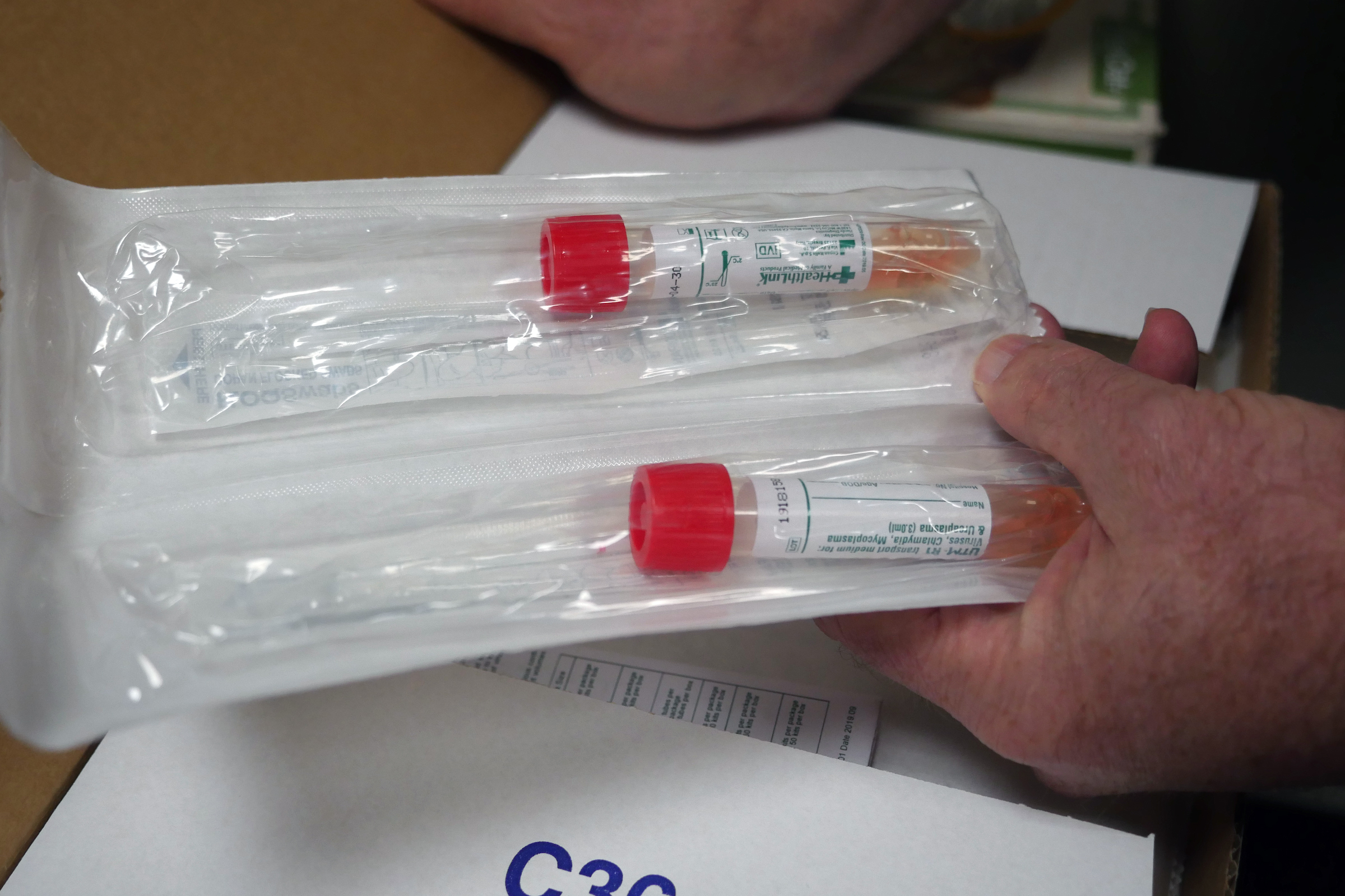 A hand holds medical swabs