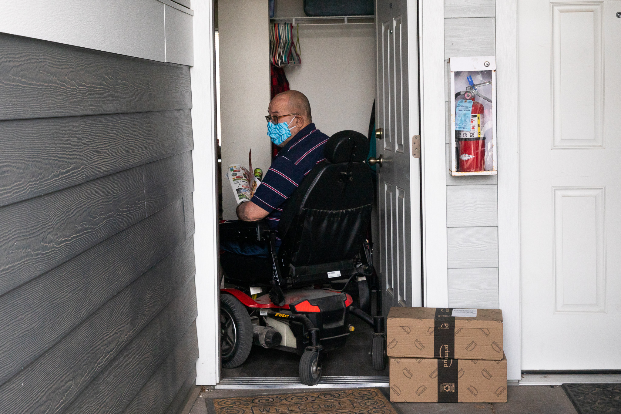 Scott sits in his wheelchair, framed by his front door