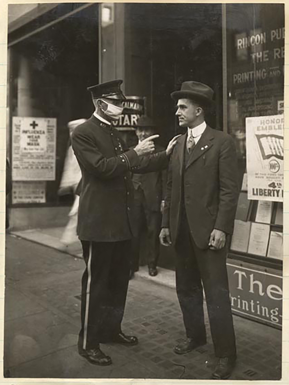 a police officer scolds a man without a mask