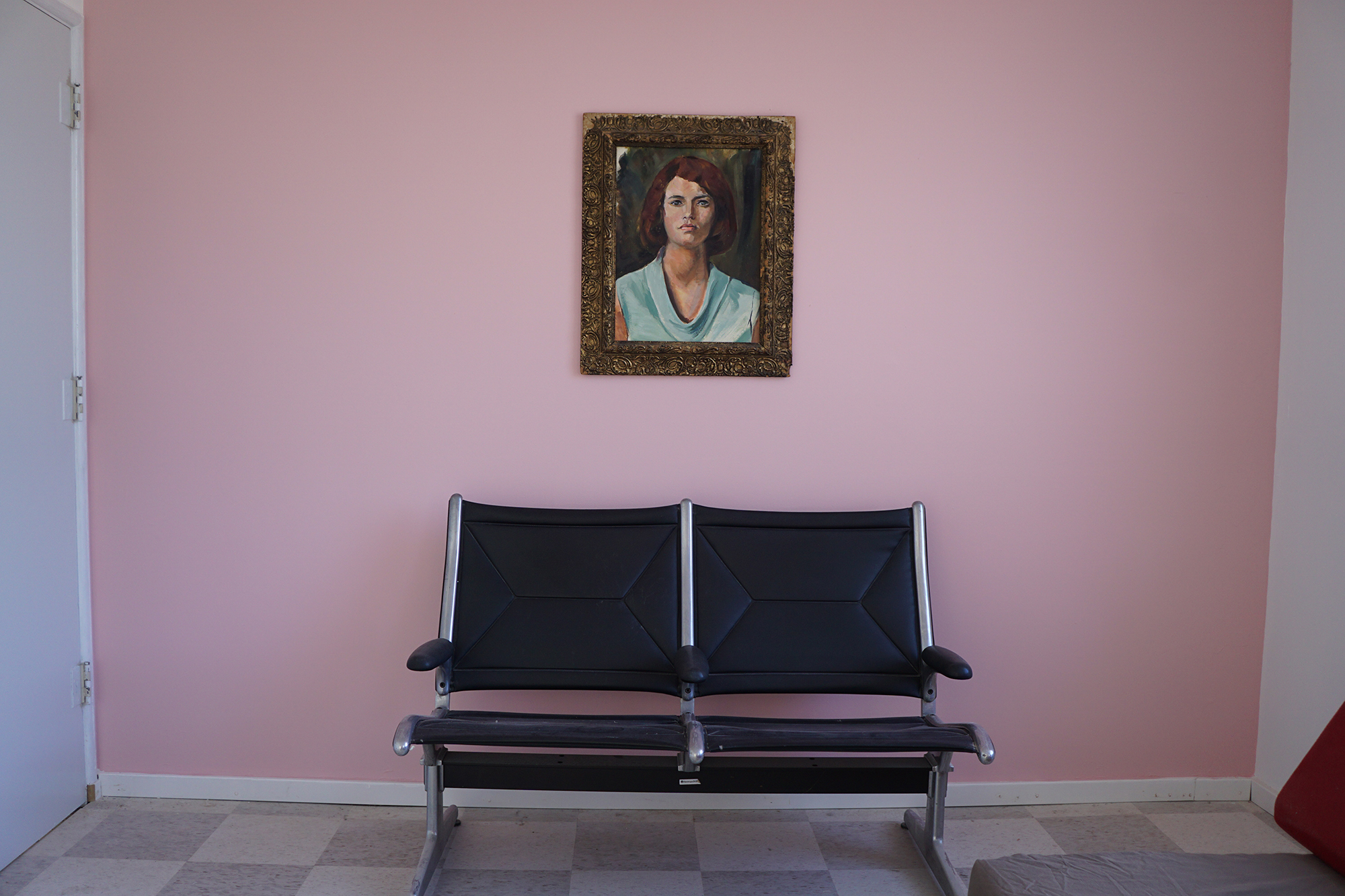 Pink wall with painting and chairs