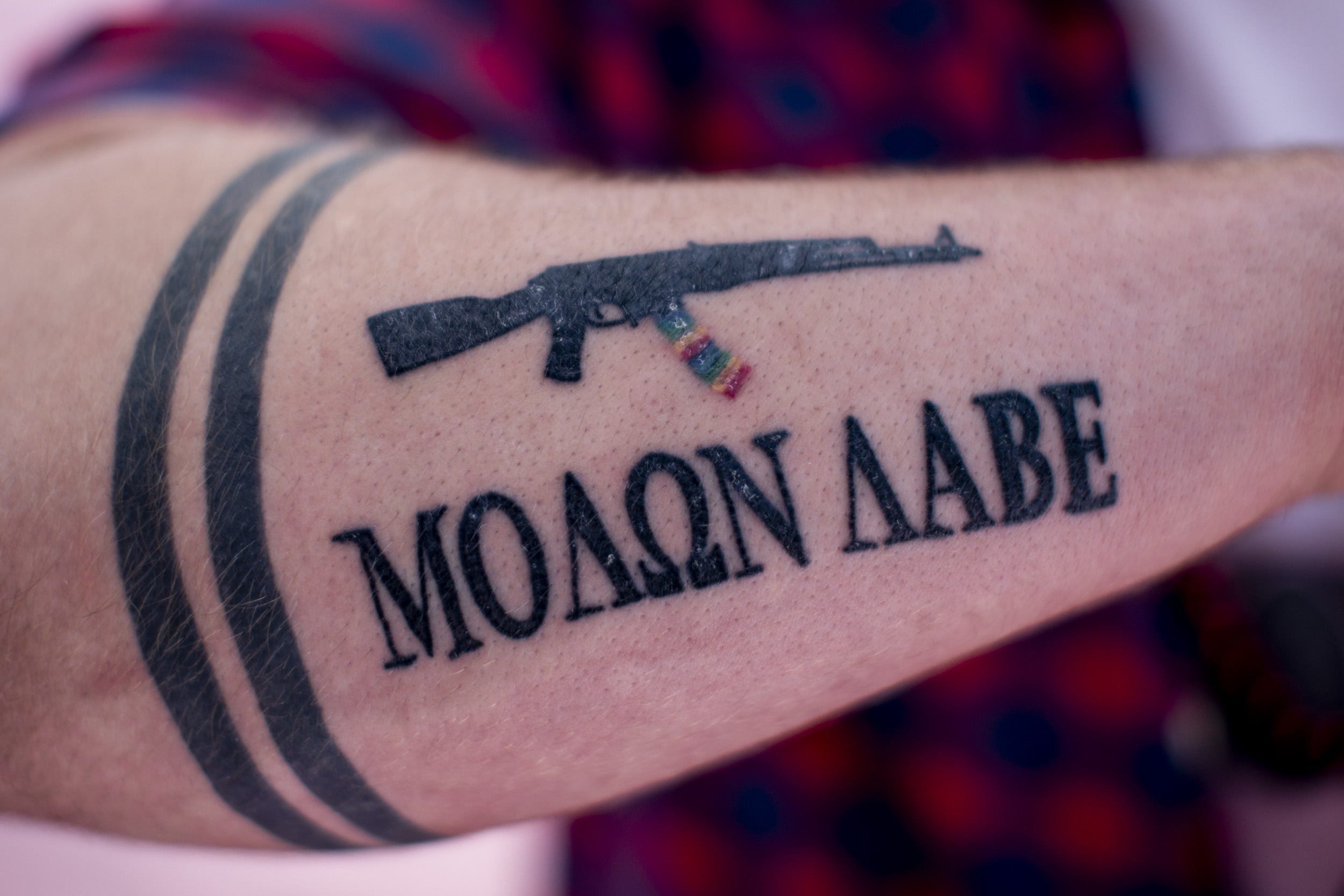 John Abbitt shows his tattoos including equality bands and the greek phrase “Molon Labe” which means “come and take it”. The phrase has been adopted by gun rights advocates as a defiant response to gun control legislation. But Abbitt says he doesn’t care how the phrase is used by the gun rights community. To him, the tattoo is a symbol of the continued fight for equality. “Still in 2019, being LGBTQ in many countries is a death sentence. As for my tattoos, I proudly wear on my arm what it means to me - that equality and love is a God given right that I will fight to protect even if that means fighting a mob trying to throw me and my husband off a roof for loving each other,” he says. “Like if you want my equality, come and take it.” (Photo by Dorothy Edwards/Crosscut)