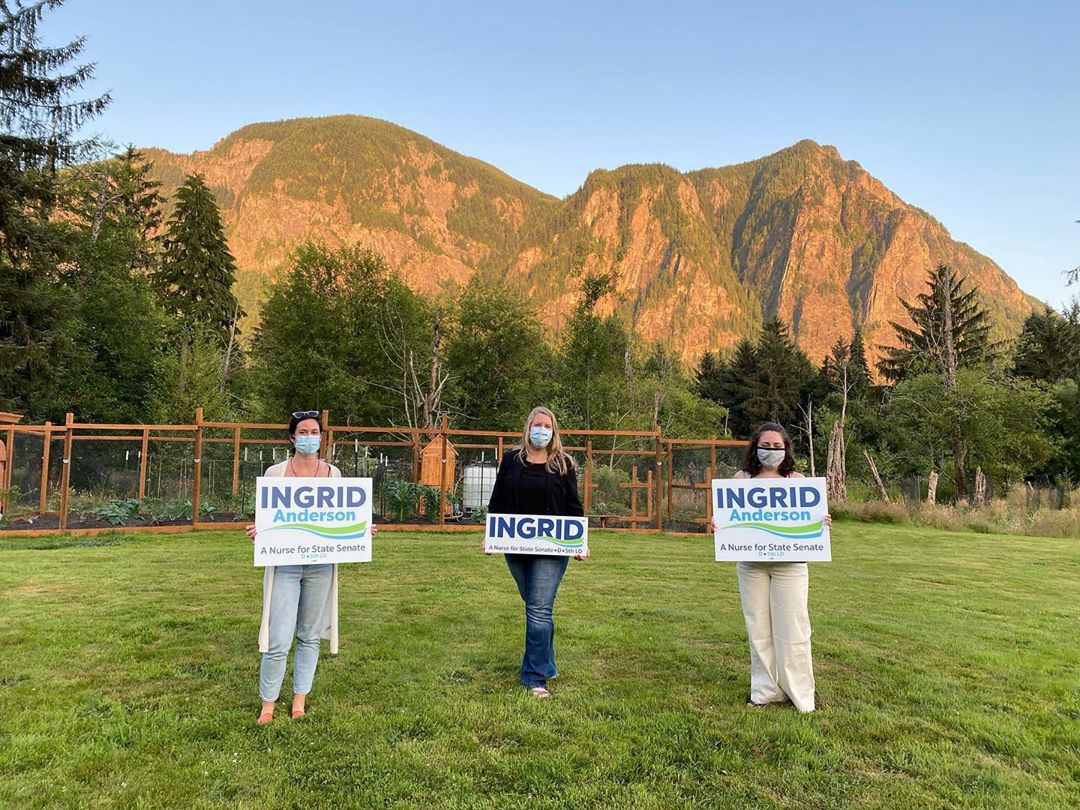 Campaign supporters of Ingrid Anderson stand apart with signs