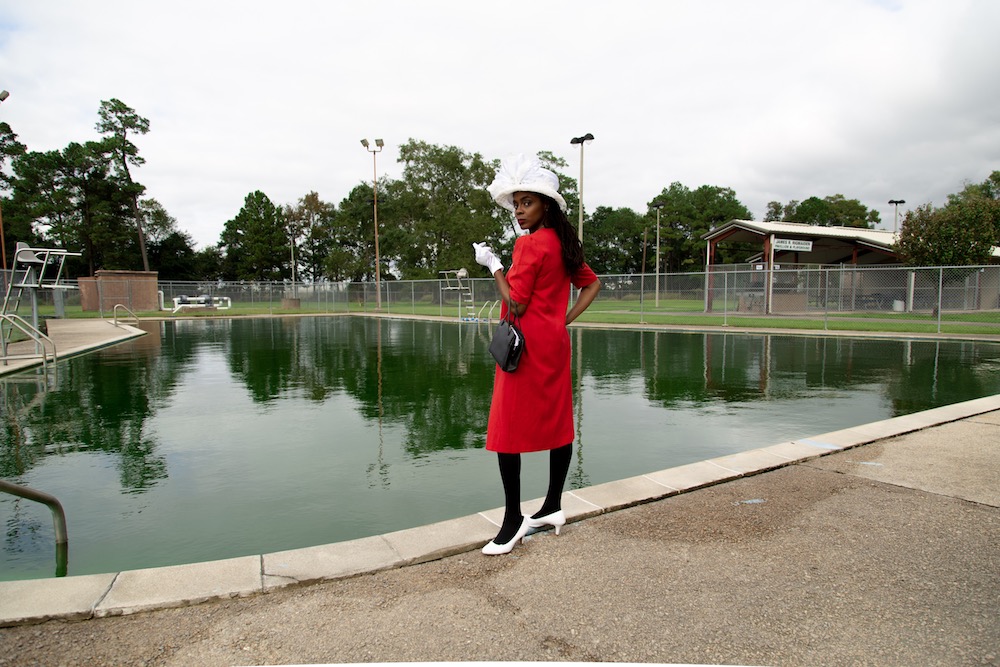 a black woman stands at the edge of a swimming pool