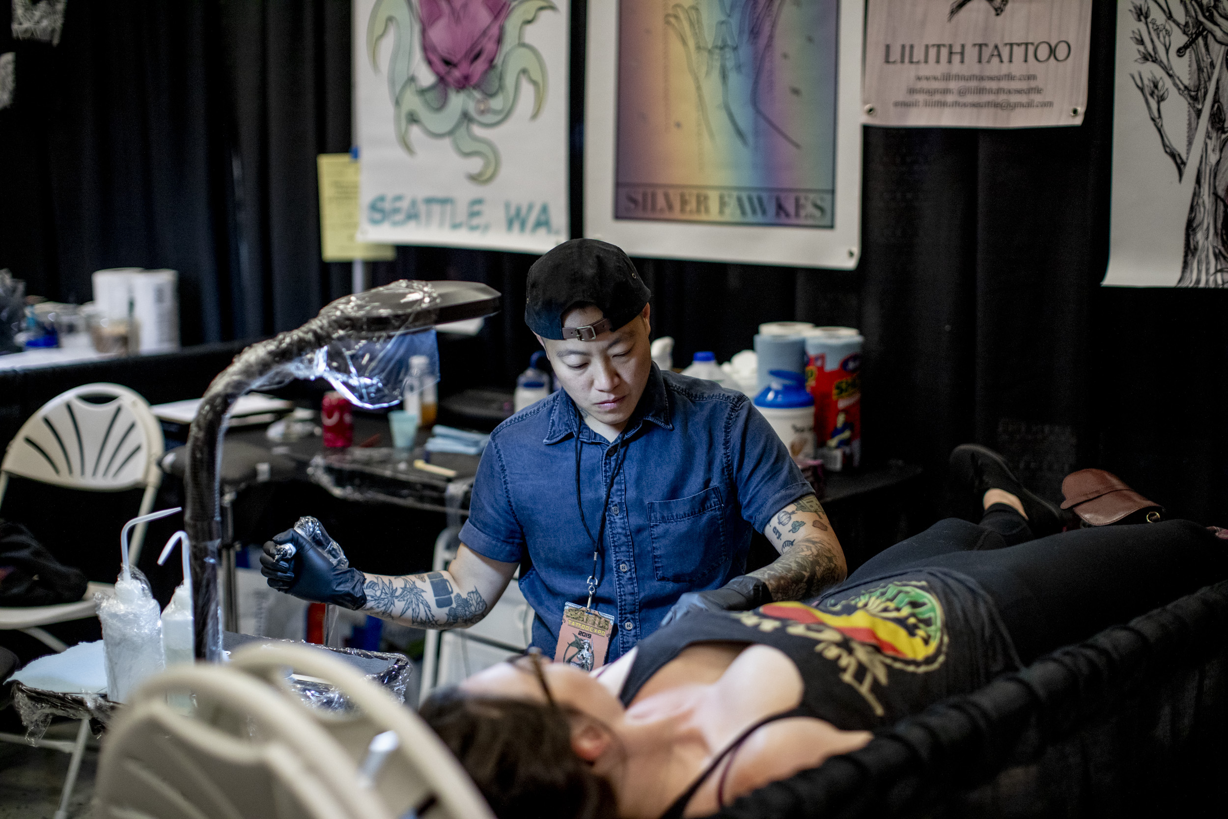Owner of Lilith Tattoo shop in Fremont Jude Vesvarut tattoos Emily Hueter during the Seattle Tattoo Expo in the Seattle Center on Aug. 16, 2019. 