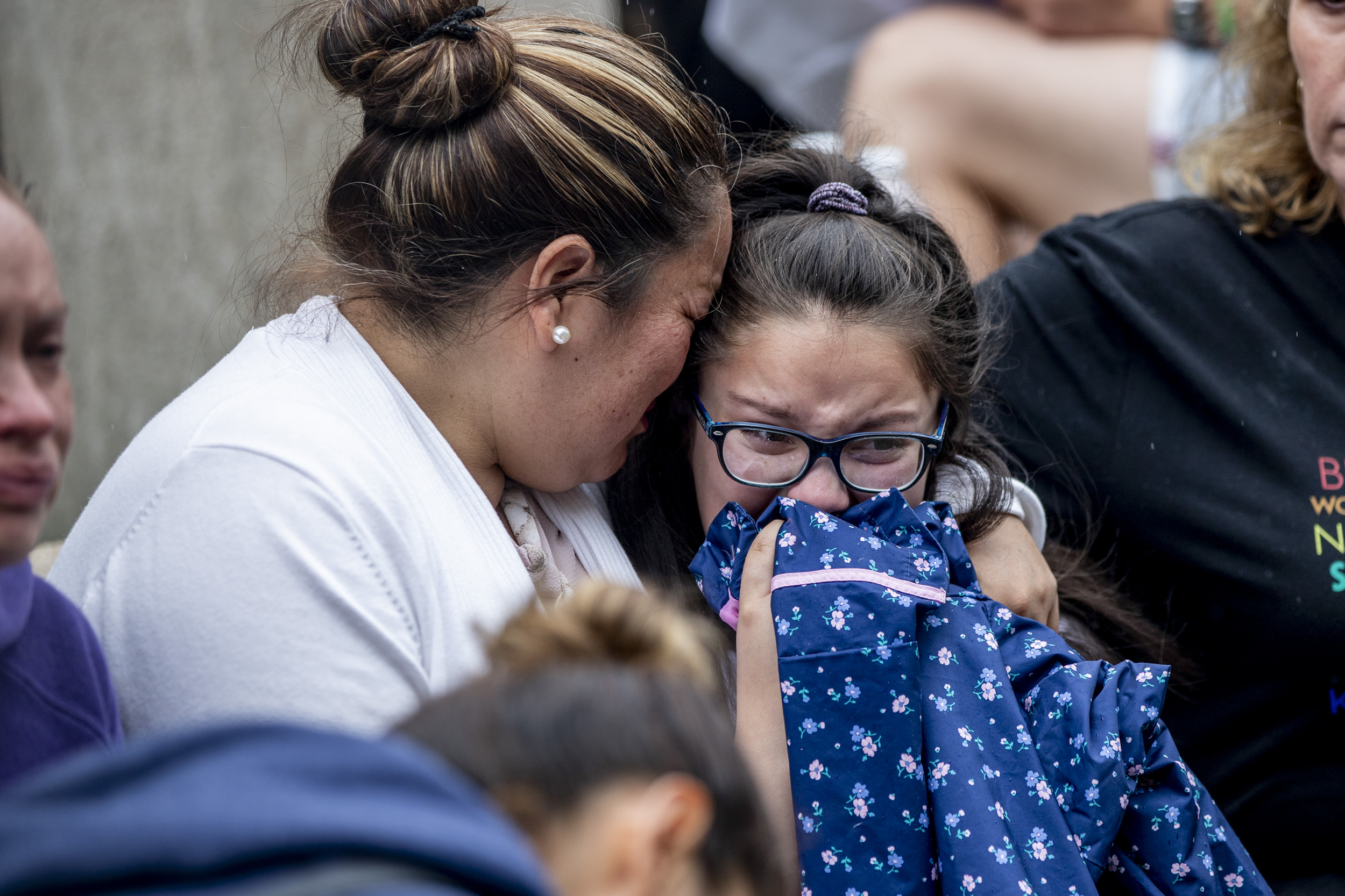 Jose Robles’ wife and daughter, Natalie, 9, embrace as they learn that Robles had been detained by ICE in Tukwila on July 17, 2019. Robles went to the ICE offices to request a stay of removal but was arrested instead. (Photo by Dorothy Edwards/Crosscut)