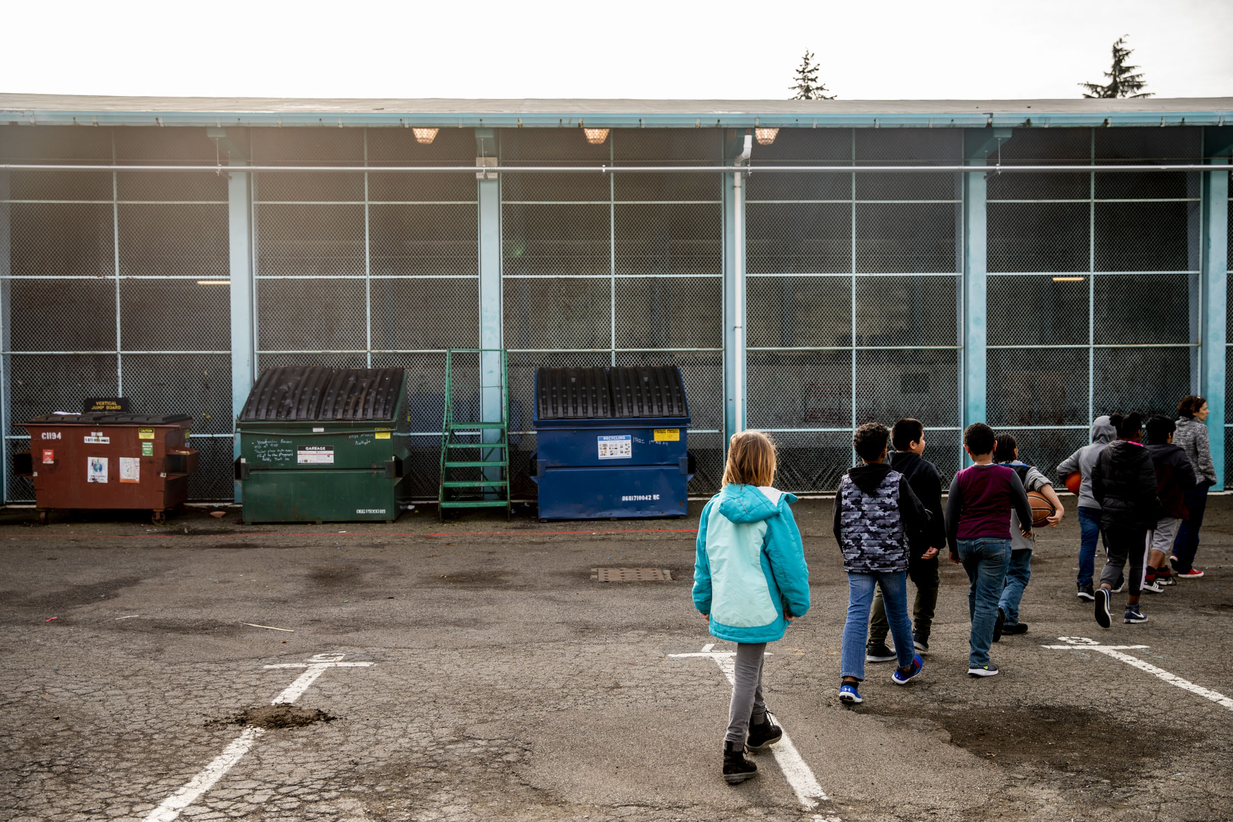 Students line up on the playground at the end of recess at Northgate Elementary School on , Jan. 31, 2018. Lack of space has forced students to share their concrete playground with Dumpsters.