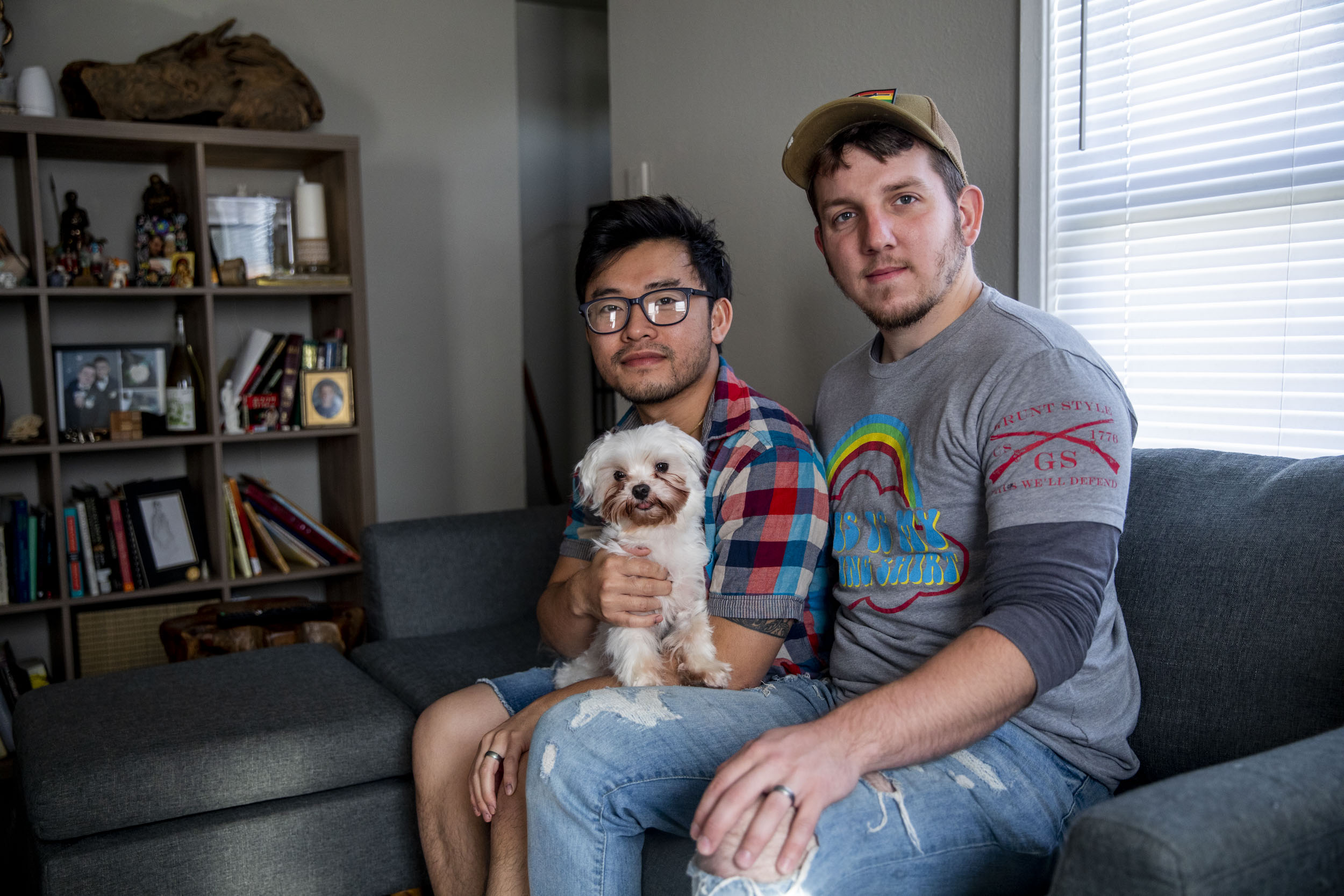 Pink Pistols administrator John Abbitt, right, and his husband Victor Chu in their Tacoma home on May 18, 2019. Though Chu is less involved with Pink Pistols than his husband and didn’t grow up with guns, he now owns his own rifle. He attributes his attitude change towards guns to his husband. “Once I took a step back, I had to take a look at the intentions. Like for John, his involvement in Pink Pistols, it’s more focused on empowering people -  and let’s face it, a lot of times the LGBTQ community feels powerless in certain situations, or threatened, or at risk. They don’t feel safe,” Chu says.(Photo by Dorothy Edwards/Crosscut)