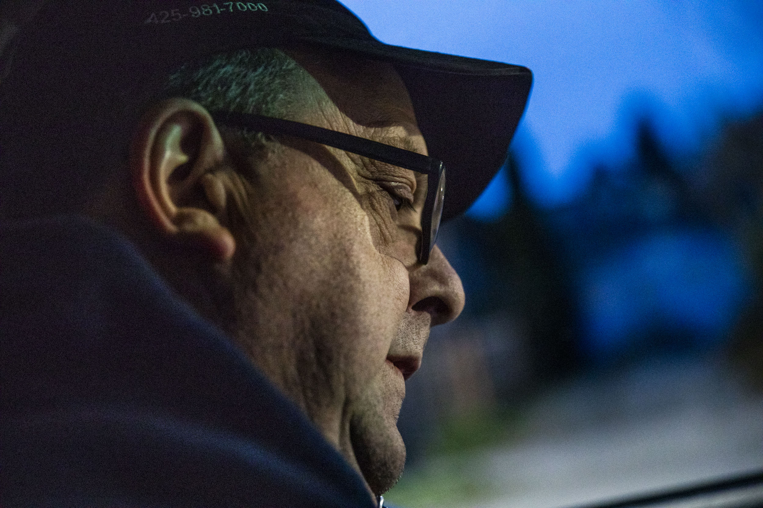 Doug Latta, 58, checks his route list in his car during his final delivery route for the Seattle Weekly on Feb. 27, 2019. (Photo by Dorothy Edwards/Crosscut)