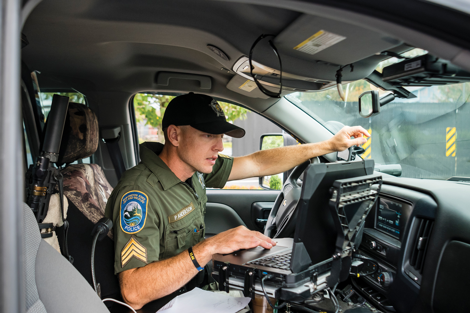 Sgt. Patrick Anderson in an vehicle using a laptop