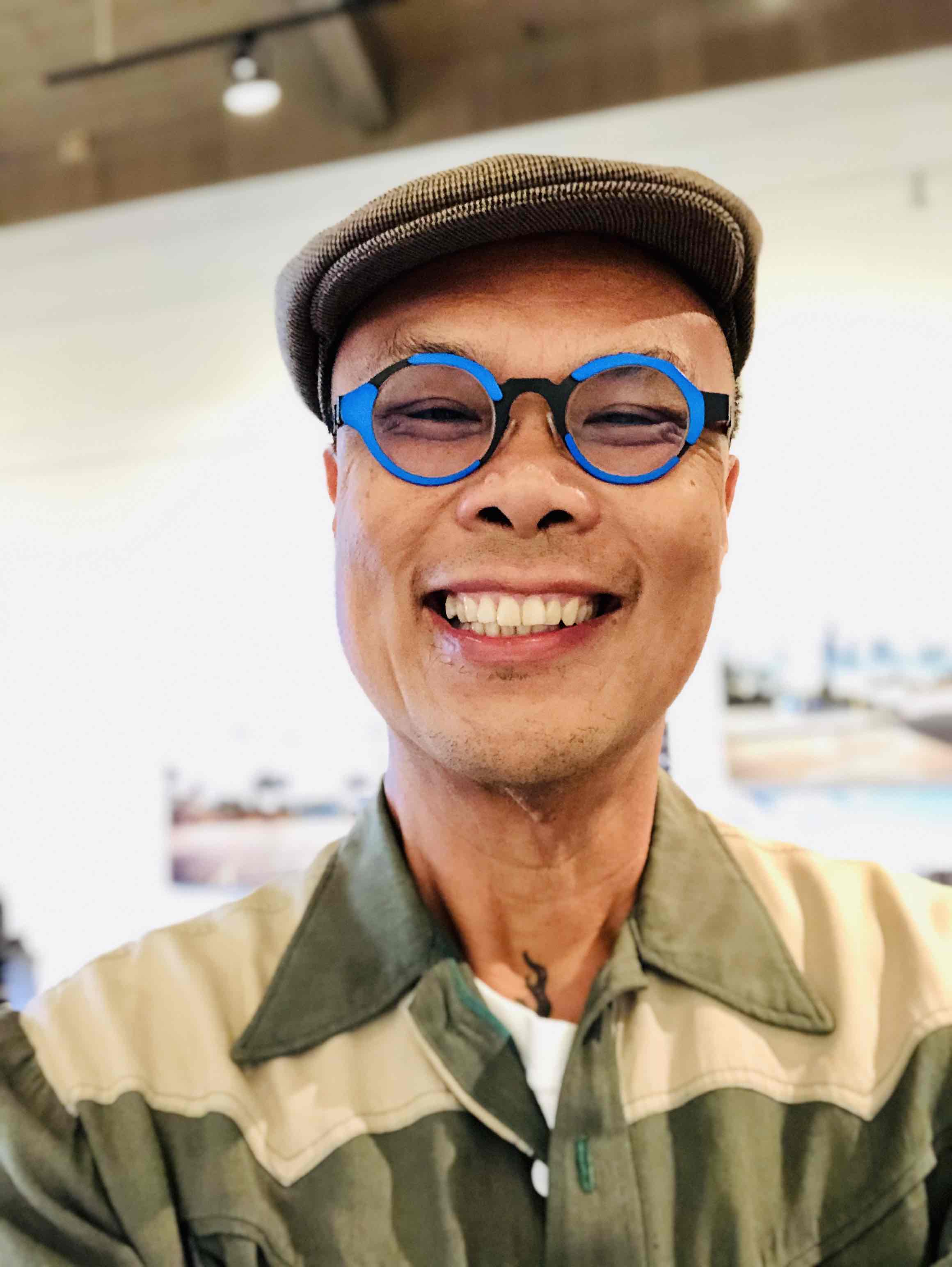 Person in blue glasses smiles for camera