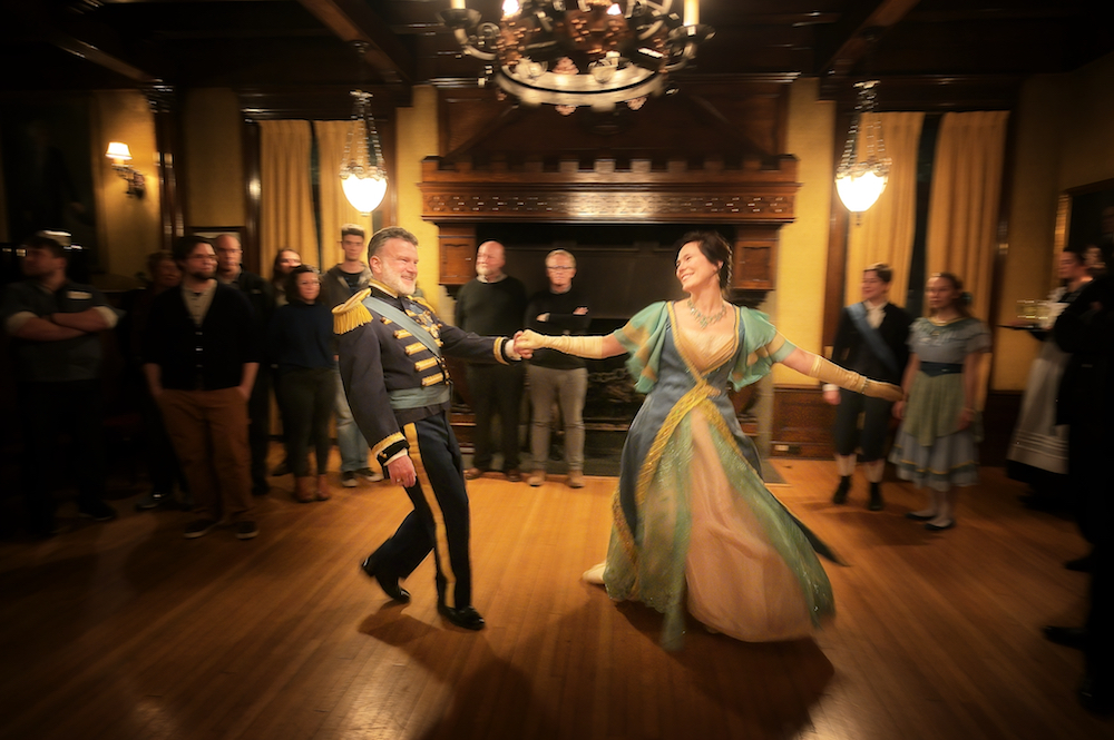 a man and a woman dancing in period costume
