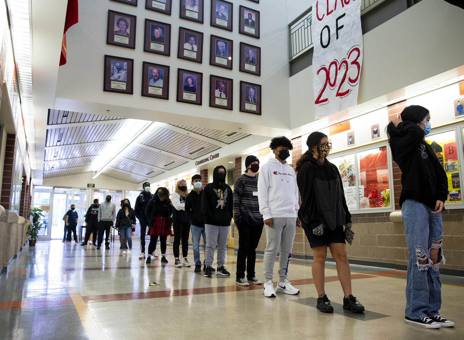 Kids in a line in a school hallway. A banner overhead reads "Class of 2023"